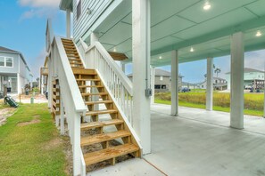 A residential building with a wooden staircase leading to a covered porch area.