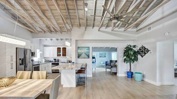 A spacious open-plan living area with a kitchen, dining table, and seating. - Oasis Retreat! - 4BR/3BA Private Pool Home! (Fort Lauderdale)