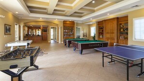 Una sala recreativa amplia con varias mesas de fútbol de mesa, billar y futbolín.