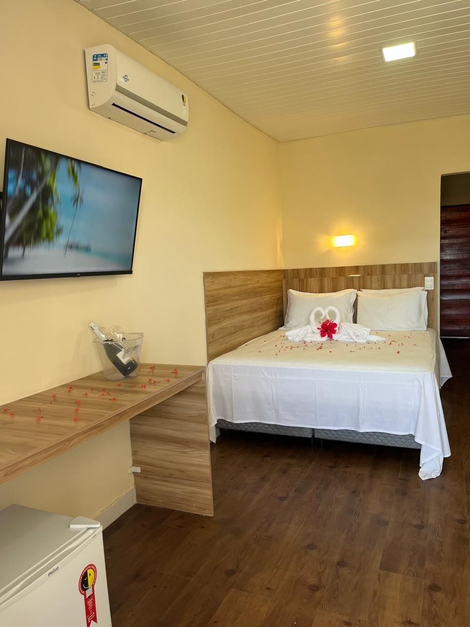 Une chambre d’hôtel équipée d’un lit, d’une télévision, d’un mini-bar et de la climatisation.