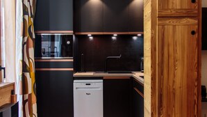 A modern kitchen with a wooden cabinet, a dishwasher, and a dining area with a table set for two. - Immodreams - Le Billat - Avoriaz (Avoriaz)