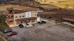 A two-story building with a sign reading "Tree Inn" and a parking area with several cars.