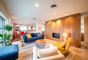 Relax in this stylish living room with a sofa, armchair, and coffee table, perfect for unwinding by the fireplace.