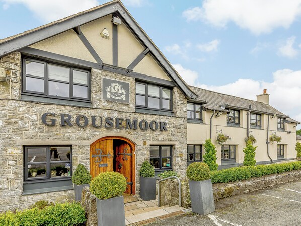 A stone building with a sign reading "Grousemoor."