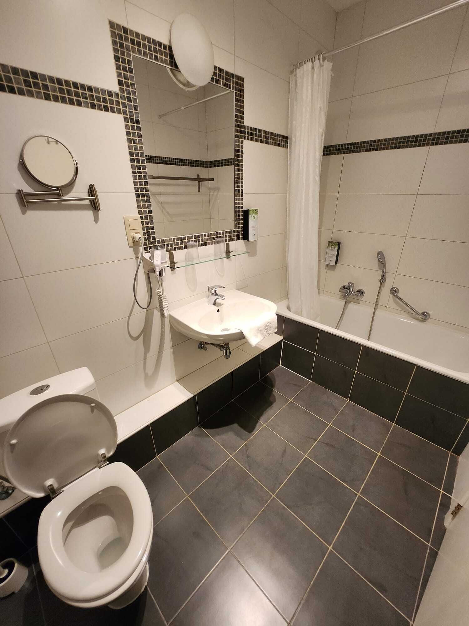 A modern bathroom with a toilet, sink, and bathtub.