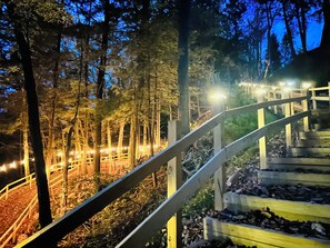 A wooden staircase with railings leading up a forested area. - River & Golf Mountain Retreat (Windham)