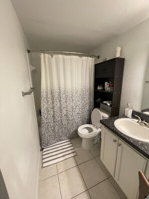 Tina con regadera, toallas, jabón, papel de baño 