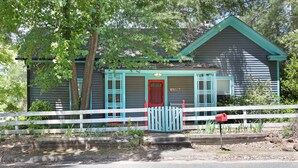 A house with a red door, number 130G, surrounded by a white picket fence and greenery. - Vintage Cottage less than 3 mi from Duke Hospital (Durham)