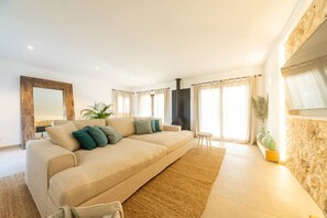 Una sala de estar con un sofá color beige, una mesita y una chimenea.