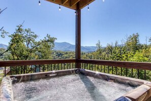 Un jacuzzi en un balcón con vistas a la montaña.