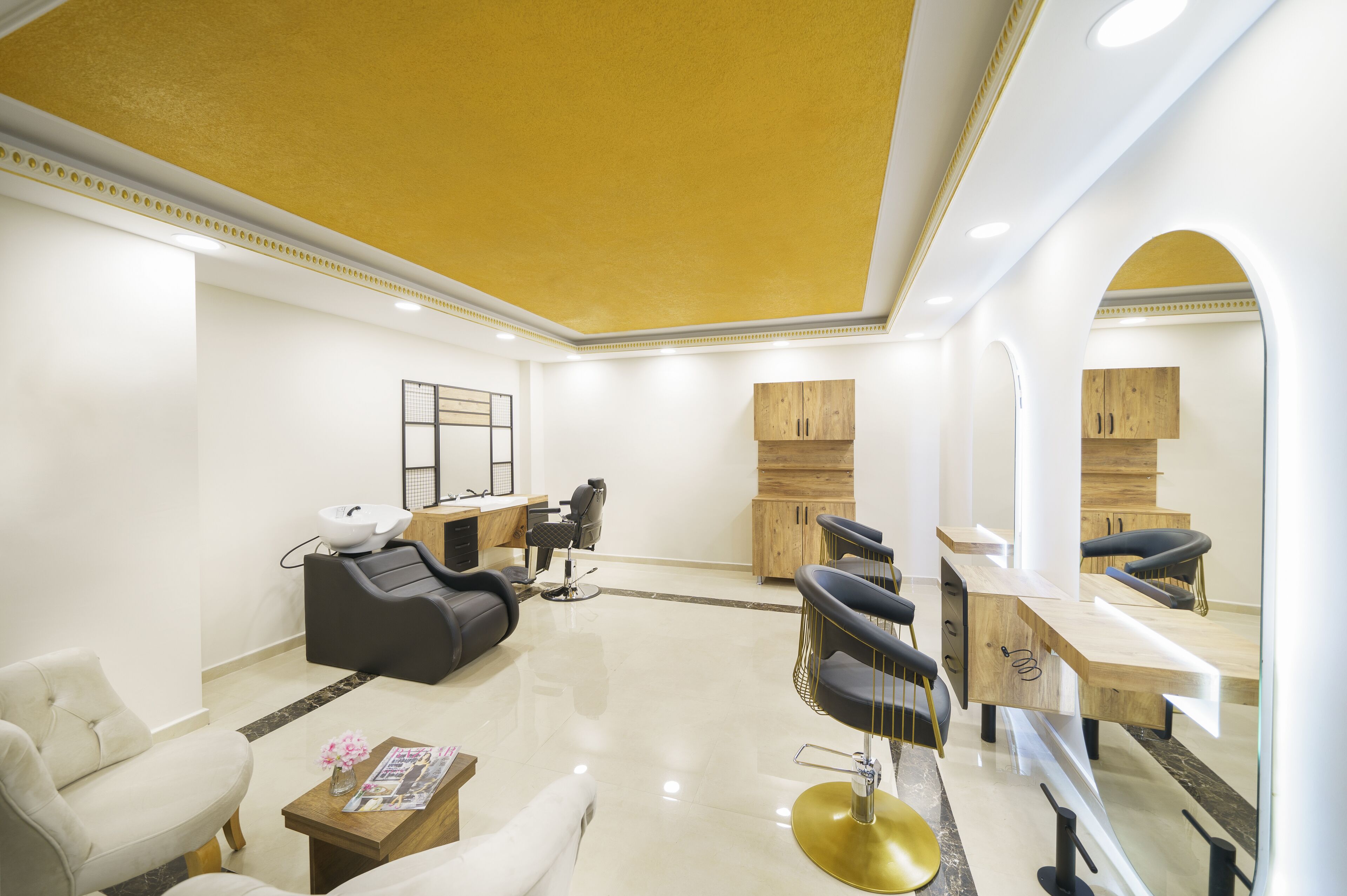 A modern salon with a clean, minimalist design, featuring a reception desk, multiple seating areas, and a polished floor.