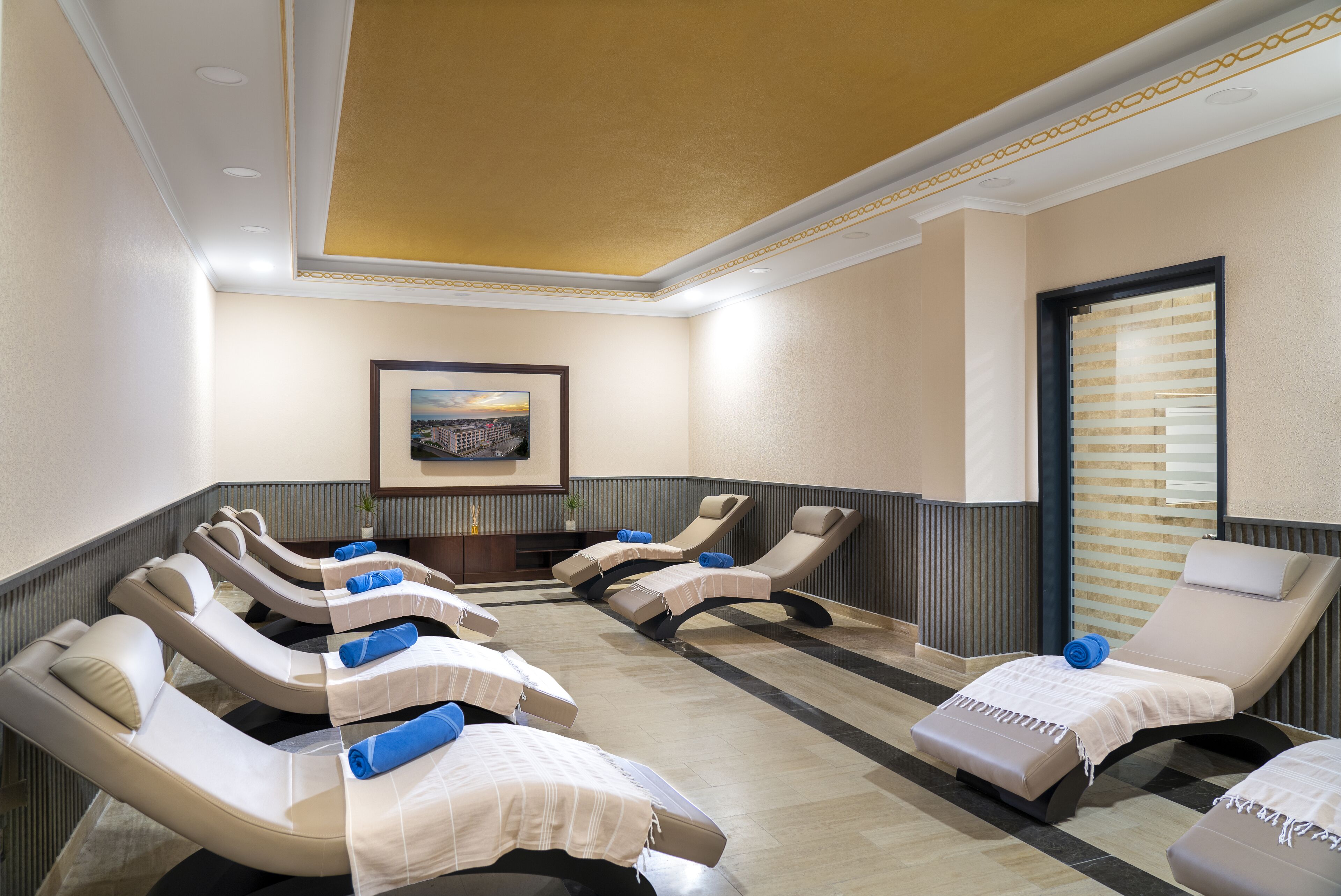 A room with multiple reclining massage chairs, a framed picture on the wall, and a window with blinds.