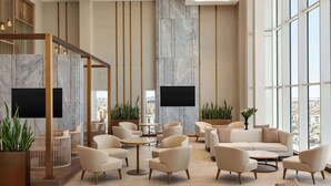 A spacious lobby with high ceilings, marble walls, and large windows offering city views. - Ramada By Wyndham Riyadh King Fahd Road (Riyadh)