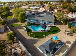 Il s’agit d’une propriété résidentielle dotée d’une piscine, de mobilier de jardin et d’un espace extérieur aménagé avec un coin salon couvert.