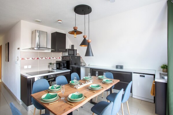 A modern kitchen with a dining area set for six. - ESPLANADE BelleÉtoile SPA Sauna Jeux Colmar (MUNTZENHEIM)