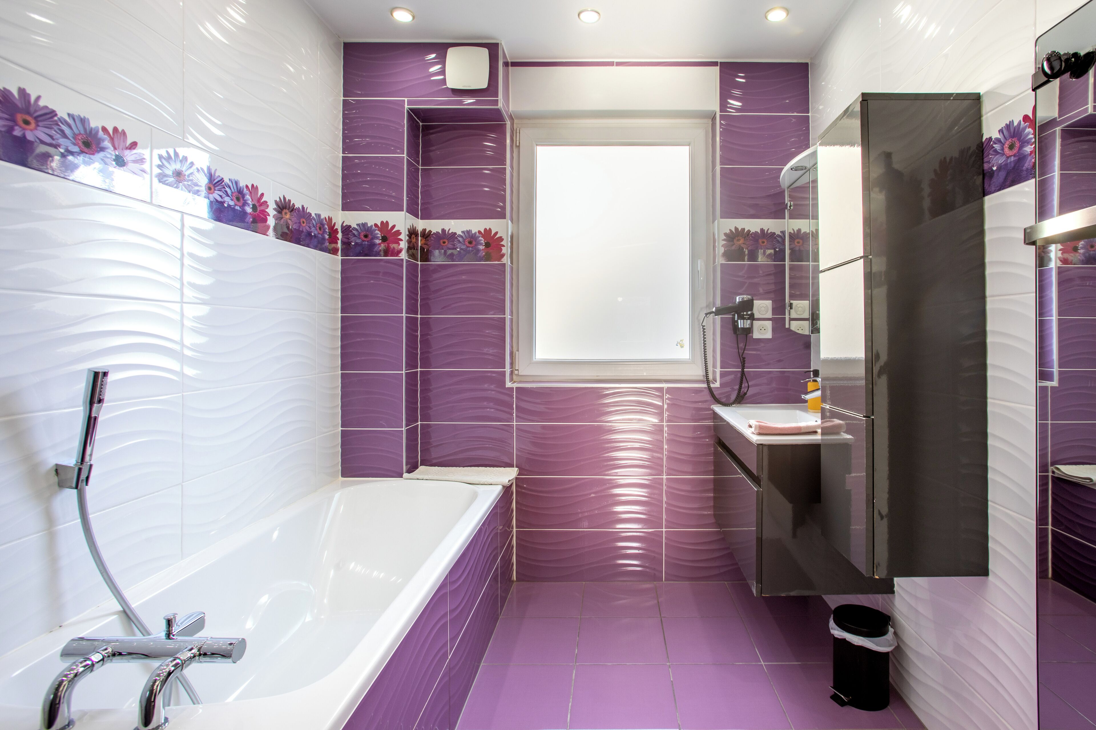 A modern bathroom with a bathtub, a sink, and a shower area.