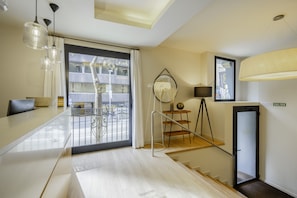 Enjoy a spacious room with a large window offering a view of the outside, a seating area with a sofa and coffee table, and a staircase leading to an upper level.