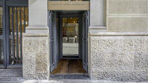 A hotel entrance with a sign reading "EXCLUS VE ROOMS&APARTMENTS" and a visible room number "Arbou 228".