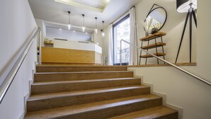 Una escalera de madera conduce a un rellano con una zona de cocina.