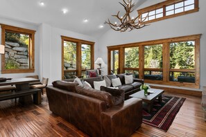 Relax in this stylish living room with a leather sofa, coffee table, and dining area.