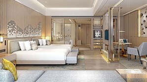 Una habitación de hotel moderna con una cama grande, un escritorio y una zona de estar.