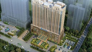 Un edificio de gran altura con un letrero destacado que dice "WYNDHAM", rodeado de follaje y un estacionamiento.