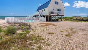 A beach house with a pool, a deck, and a view of the ocean. - Just Beachy: Beachfront, Private pool, Pet Freindly (St. George Island)