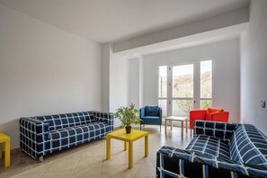 A living room with two sofas, a small table, and a chair.