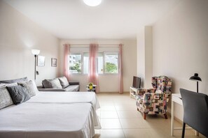 Habitació d'hotel amb dos llits, televisió, escriptori i una cadira.