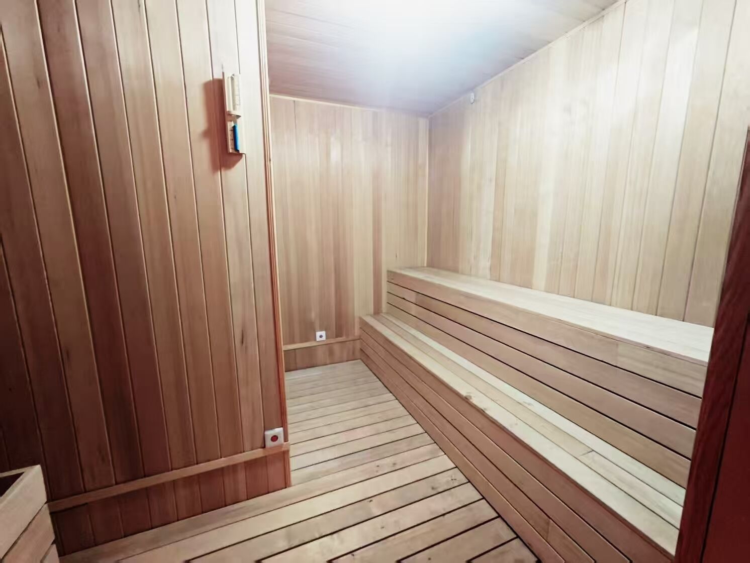 A sauna room with wooden walls and benches.