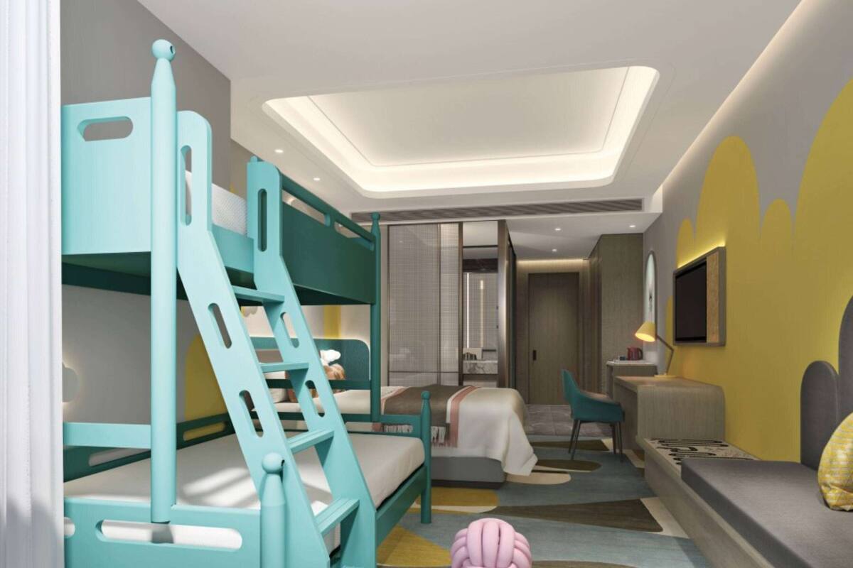 Une chambre d’enfant avec des lits superposés, un bureau et une chaise.