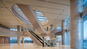 A spacious interior with a central spiral staircase, large windows, and a modern architectural design.