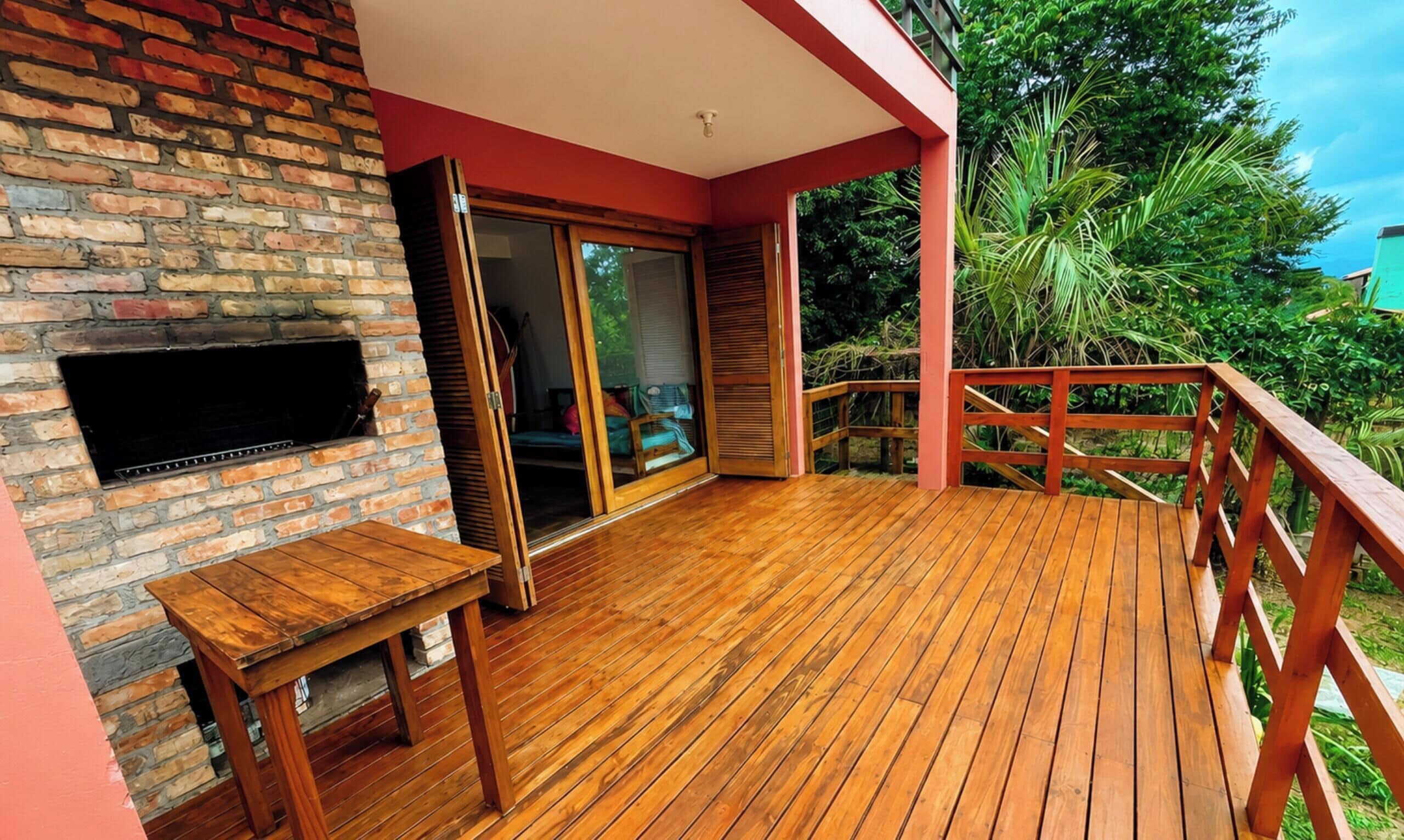 A wooden deck with a brick wall and a television mounted on it.