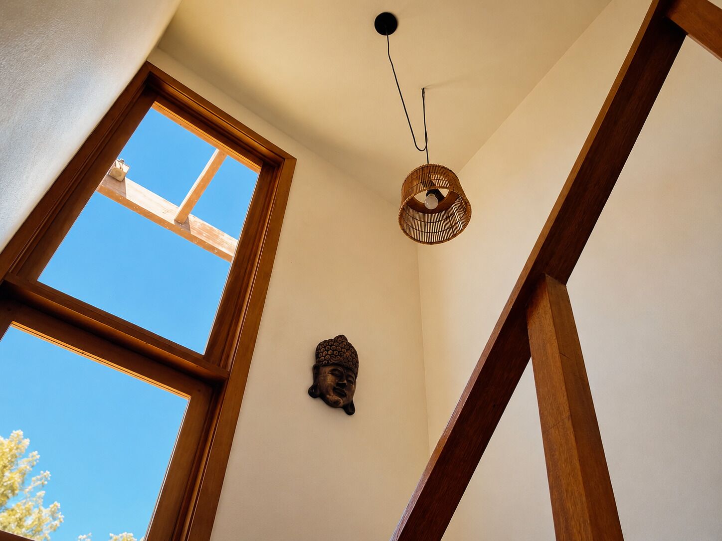 A room with a skylight, a hanging light fixture, and a wall-mounted decoration.