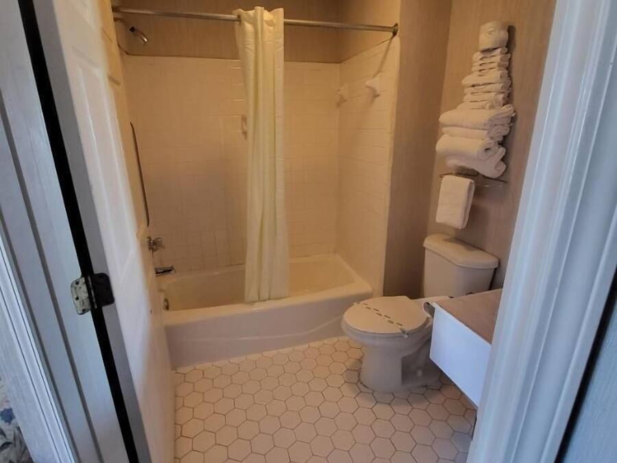 Un baño con ducha, inodoro y perchero.
