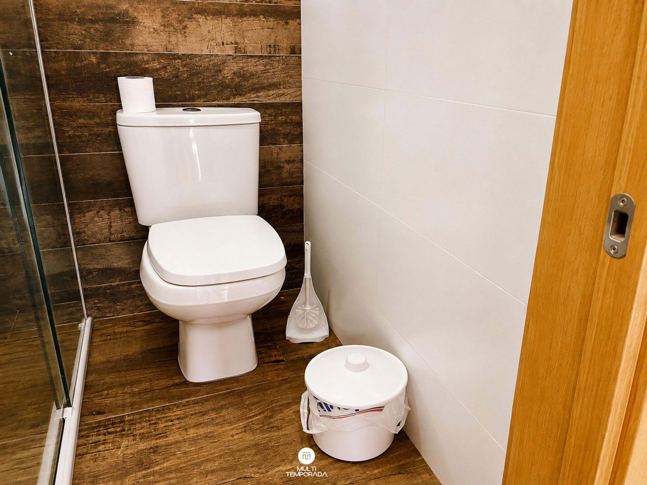 A bathroom with a toilet, a bidet, and a cleaning bucket.