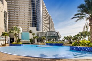 Relax by the infinity pool surrounded by lush greenery and palm trees.