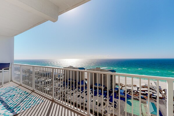 Enjoy breathtaking ocean views from this balcony with a striped floor and comfortable lounge seating.