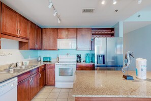 Enjoy cooking in this well-equipped kitchen with a stove, microwave, refrigerator, and sink.