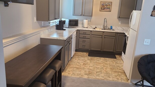 Cocina compacta con mesa de comedor, electrodomésticos integrados y una pequeña zona de estar.