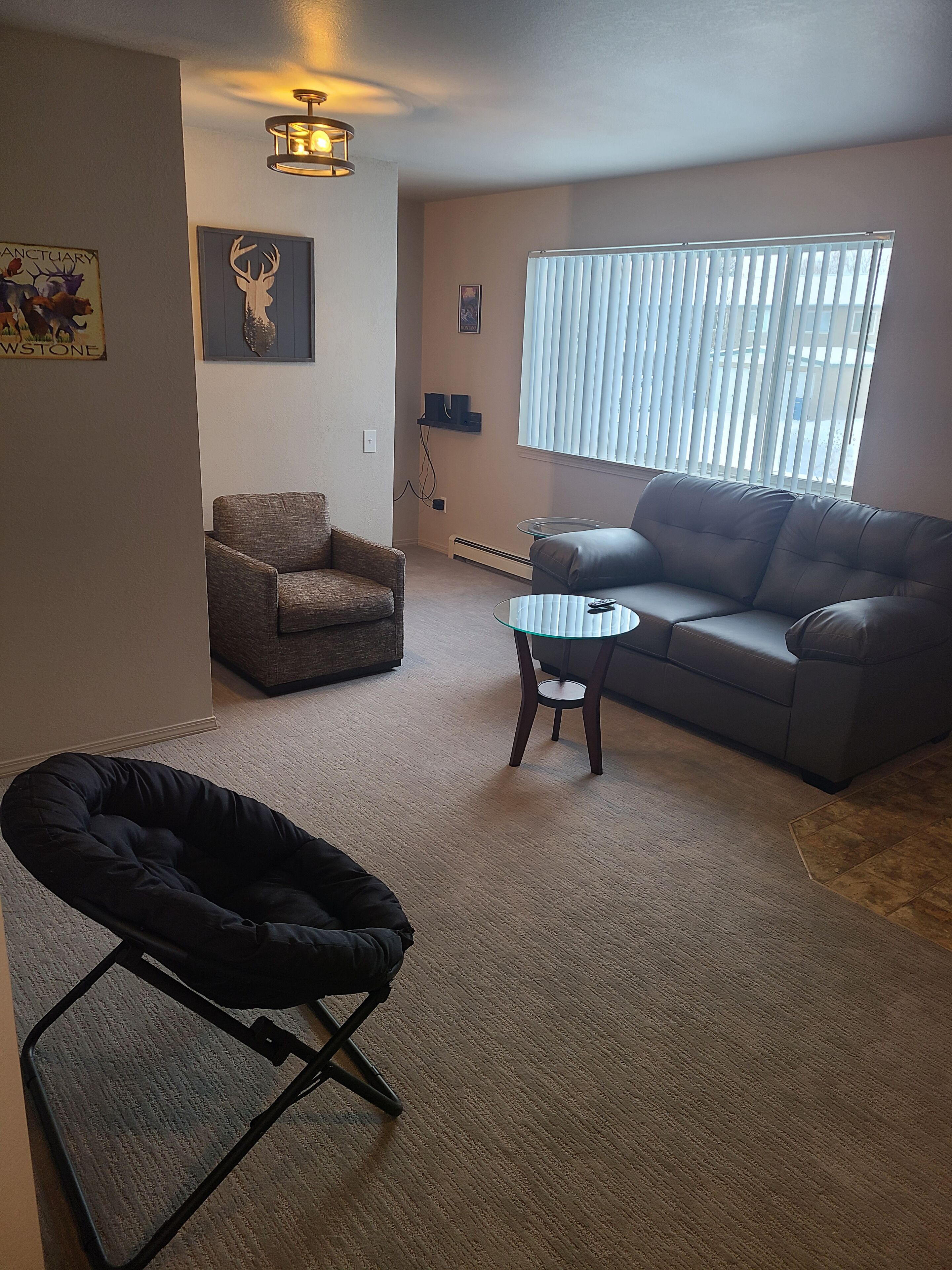 Een woonkamer met een bank, fauteuil en een klein bijzettafeltje.