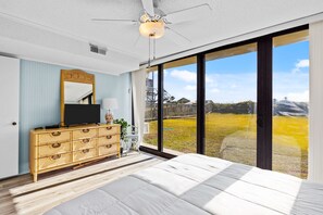 Relax in this serene bedroom with a large bed, dresser, and flat-screen TV.