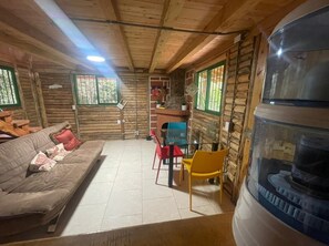A log cabin interior with a sofa, chairs, a table, and a fish tank. - Verde Vivo - Divine cabin in the middle of the forest (El Rosario)