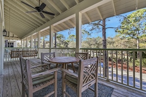 Relax in this serene outdoor space with a round table and comfortable seating, surrounded by lush trees.