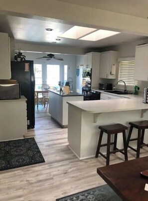 Enjoy meals in the kitchen with a central island and dining area featuring a table and bar stools.