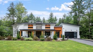 A modern two-story house with a front porch, a garage, and a well-maintained lawn. - Luxury Retreat in the Mountains! (Thornton)