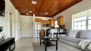 A modern kitchen with wooden cabinets, a stainless steel refrigerator, and a microwave.