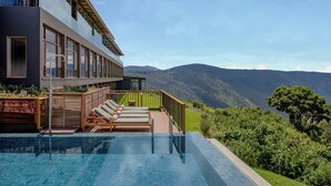 A modern hotel with a rooftop infinity pool, offering a scenic view of mountains and lush greenery. - Ngorongoro Lodge member of Meliá Collection - The Leading Hotels of the World (Ngorongoro)