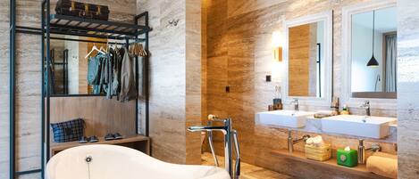 A modern bathroom with a freestanding bathtub, dual sinks, and a mirror above the sinks.