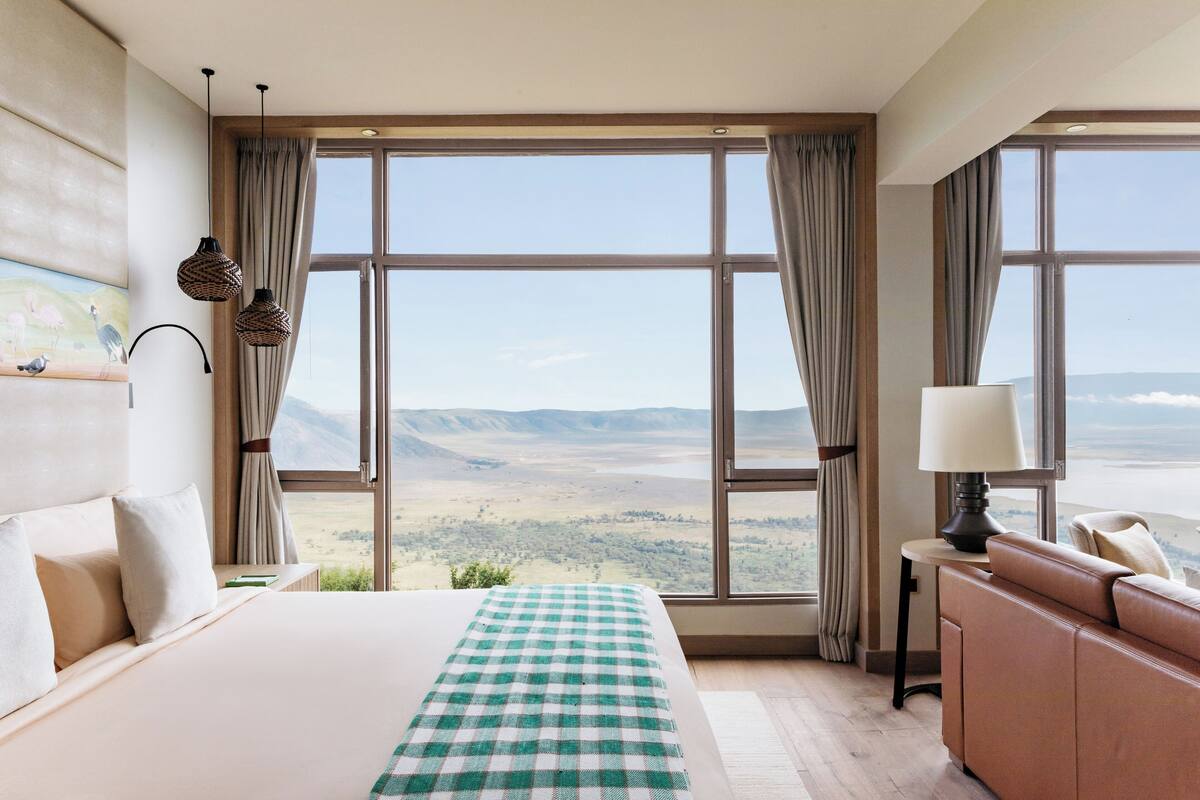 A hotel room with a large window offering a scenic view of the countryside.